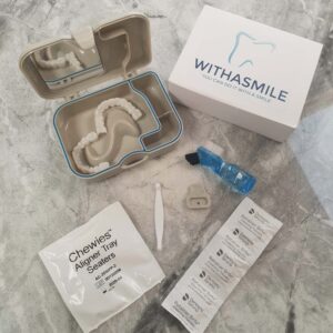 Vista aérea de un kit de carillas dentales Withasmile, colocado sobre una mesa, mostrando las carillas y todos los accesorios