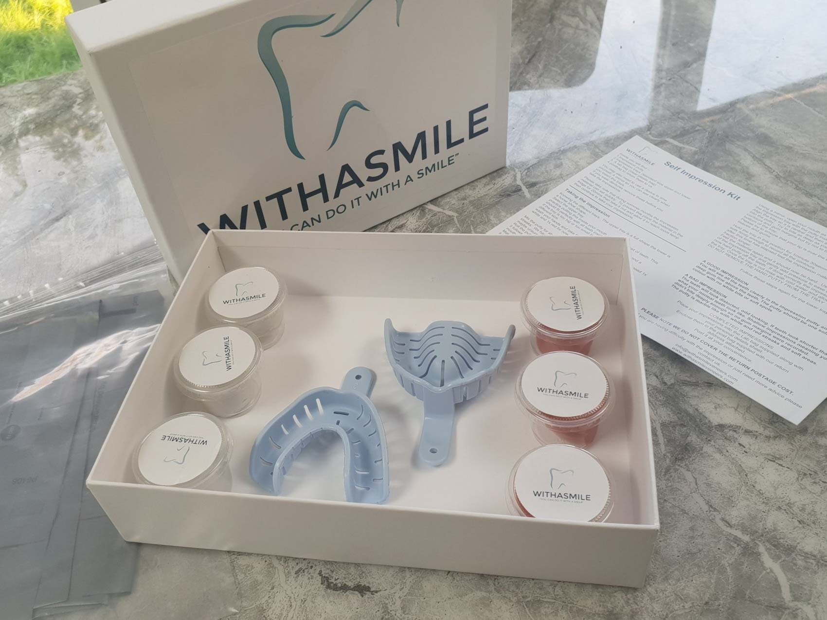 An open box displaying an impression kit used for creating personalised dental veneers